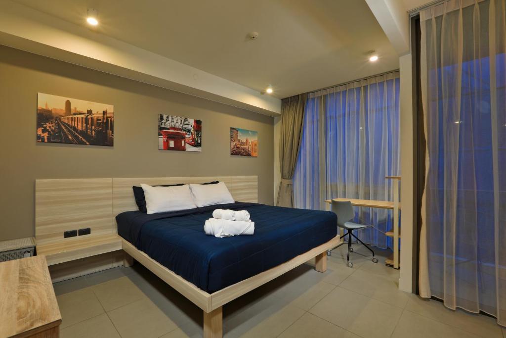- une chambre avec un lit bleu et des serviettes dans l'établissement Oceanstone by Holy Cow, studio, next building view, à Bang Tao Beach