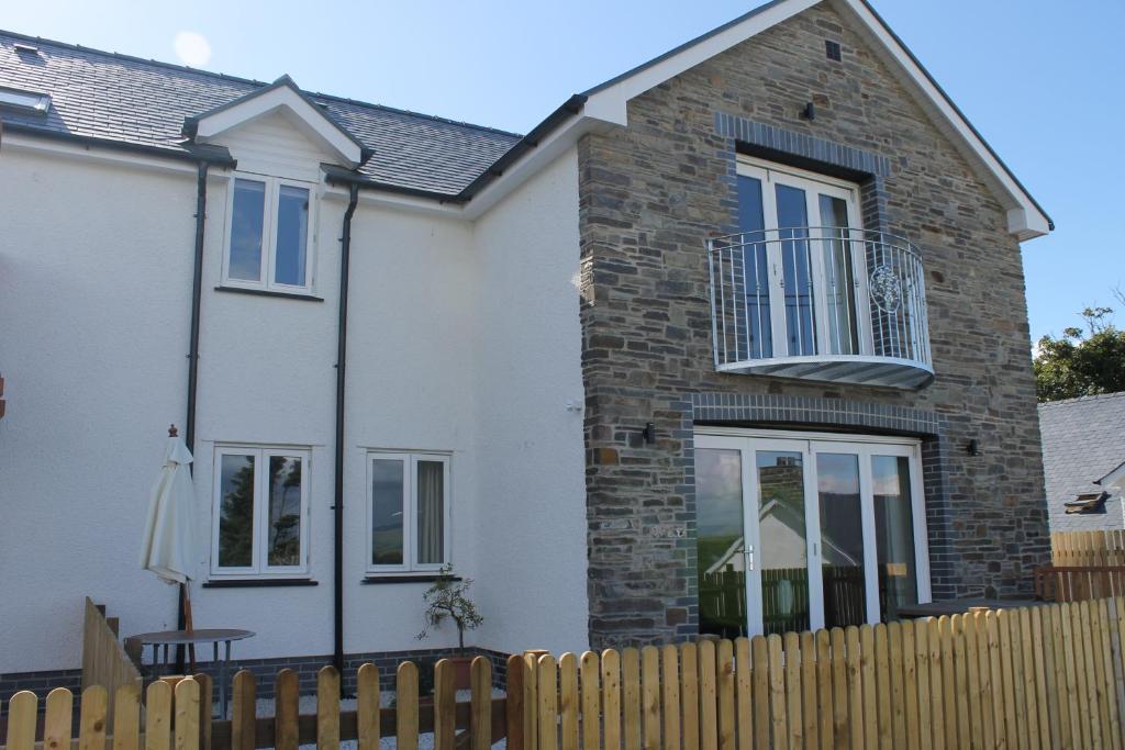 a white house with a wooden fence at Brynhyfryd in Aberystwyth