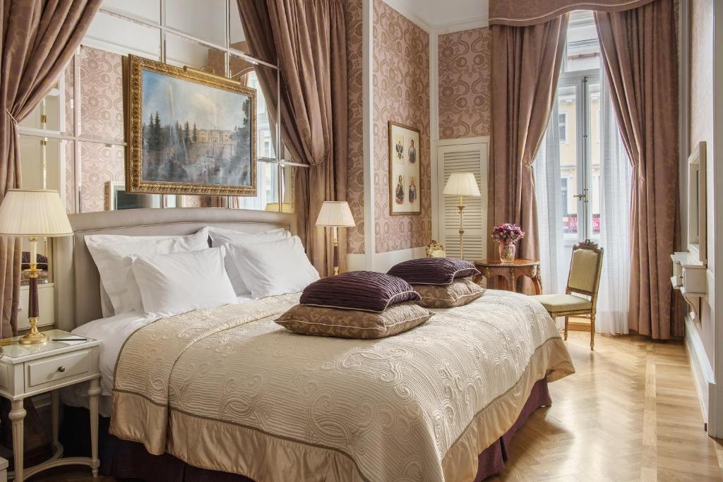 ein Schlafzimmer mit einem großen Bett mit Kissen darauf in der Unterkunft Grand Hotel Europe, A Belmond Hotel, St Petersburg in Sankt Petersburg