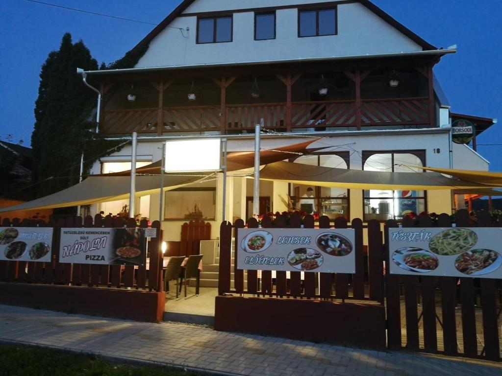 un ristorante con recinzione di fronte a un edificio di Vadásztanya Fogadó a Egerszalók