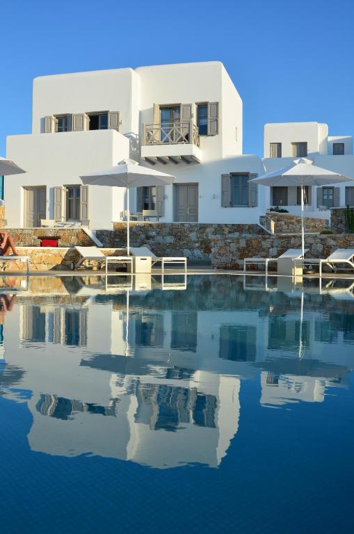 a white house with a reflection in the water at Mar Inn Hotel in Chora Folegandros