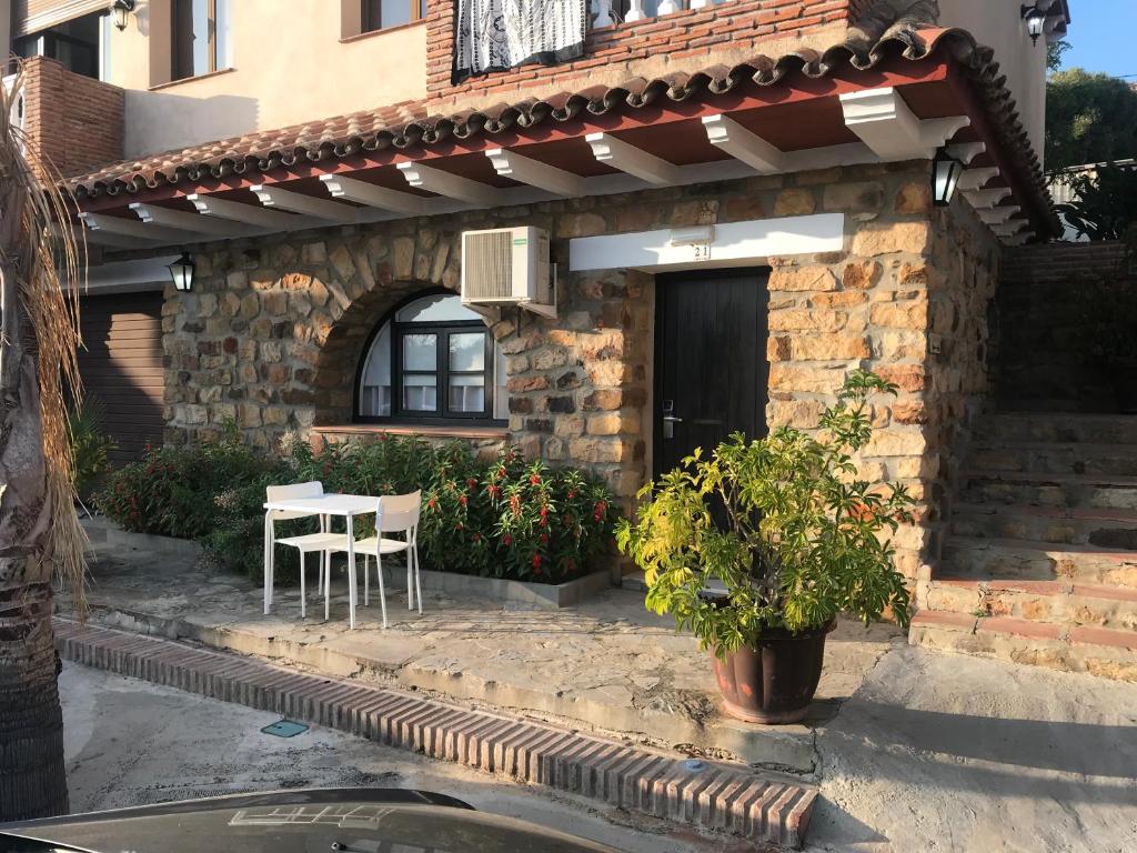 a house with a table and chairs in front of it at Dulce Nombre Hotel - Apartamentos in Tarifa
