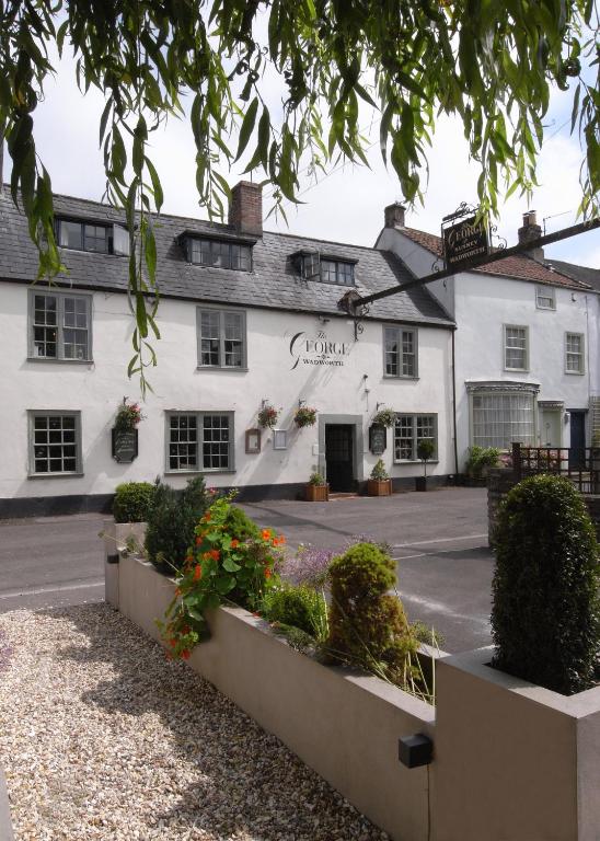 a white inn with flowers in front of it at The George at Nunney in Frome
