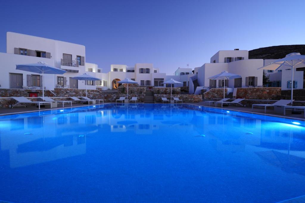 uma grande piscina azul em frente a alguns edifícios brancos em Mar Inn Hotel em Chora Folegandros