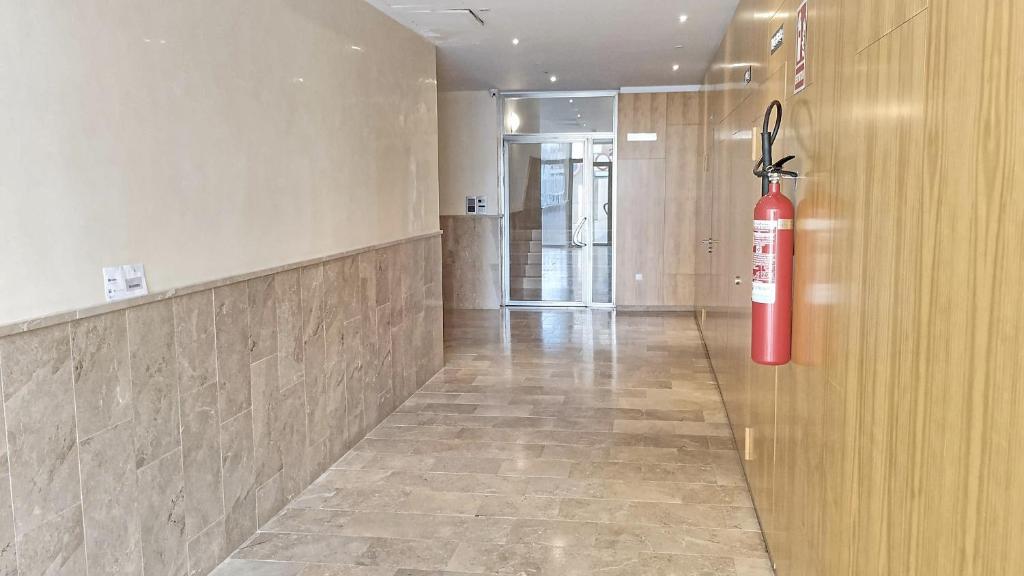 a fire extinguisher hanging on the wall of a hallway at Brisas del Guadiana in Ayamonte