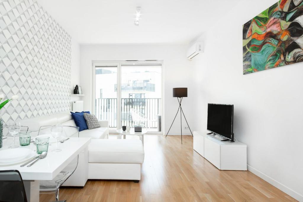 ワルシャワにあるA&D Apartment by Rentersの白いリビングルーム(白いソファ、テレビ付)