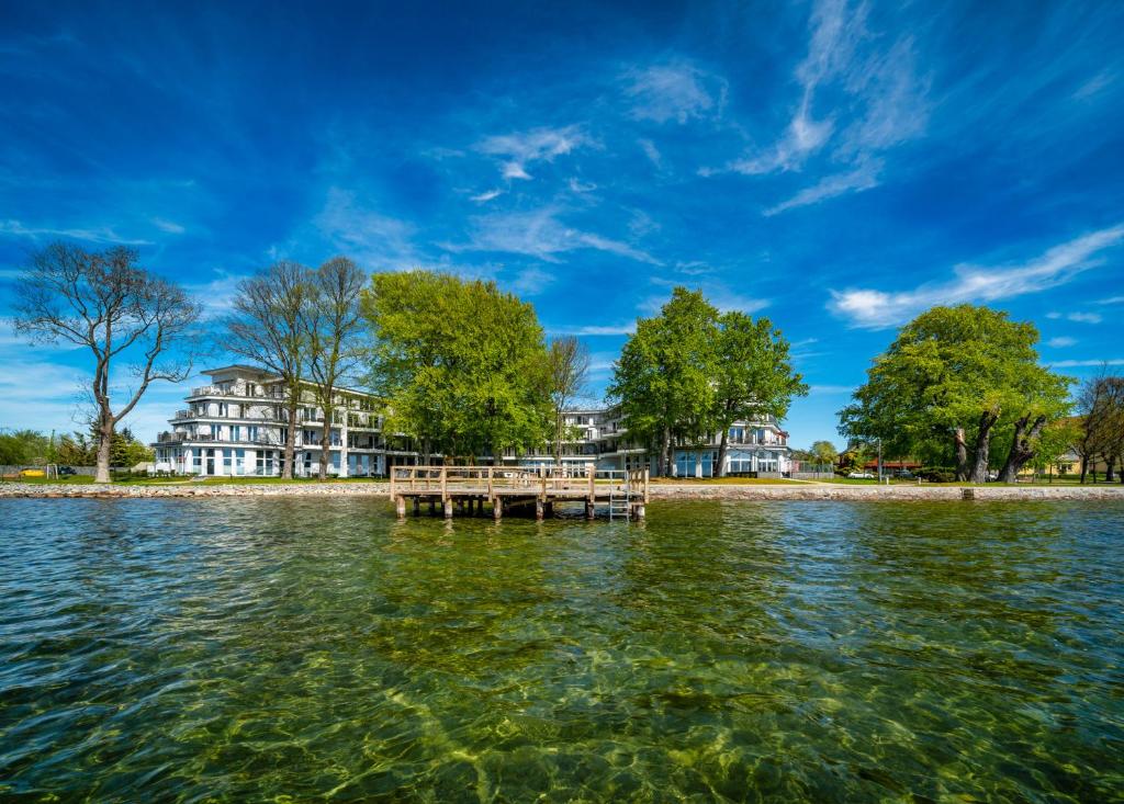 un muelle en el agua frente a un edificio en Müritzpalais en Waren