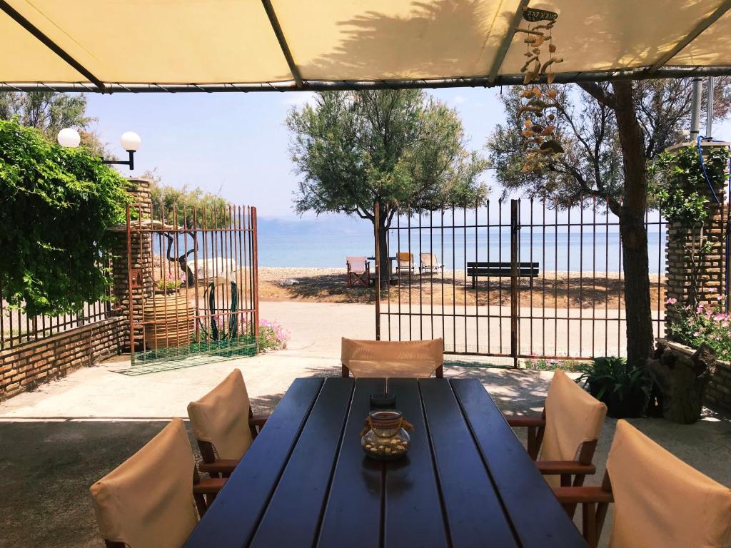 tavolo e sedie blu con cancello e recinzione di Seaside House a Aigio