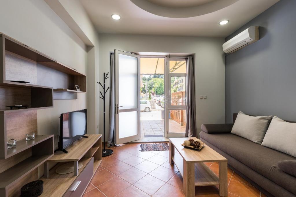 a living room with a couch and a tv at Mon-Repo Suites in Corfu Town