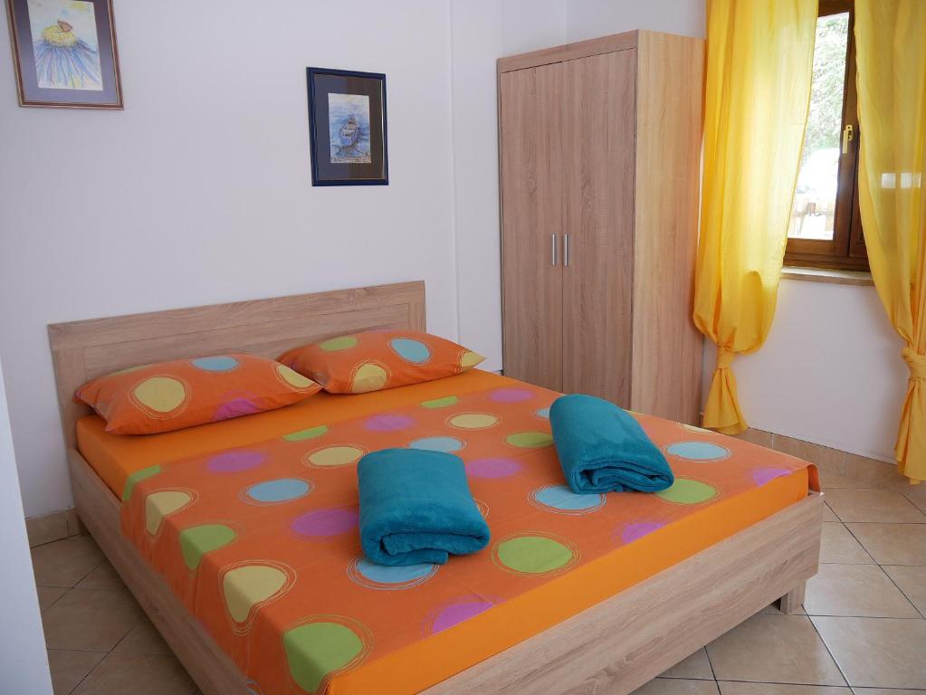 sypialnia z łóżkiem z 2 niebieskimi poduszkami w obiekcie Apartment Gaga and Nia w Krku