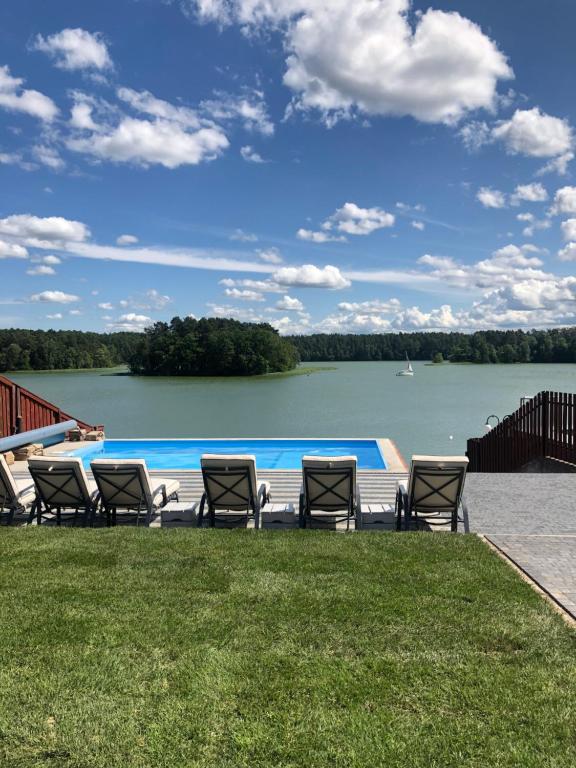 um grupo de cadeiras sentadas ao lado de uma piscina em La Masuria em Ruciane-Nida