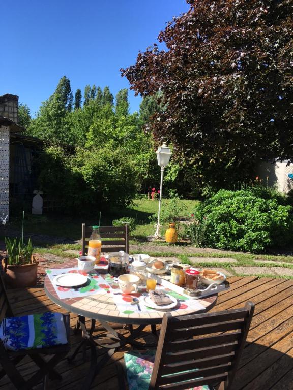 una mesa con comida en ella con dos sillas en chambre sur jardin entre Fontevraud et RignyUssé en Avoine