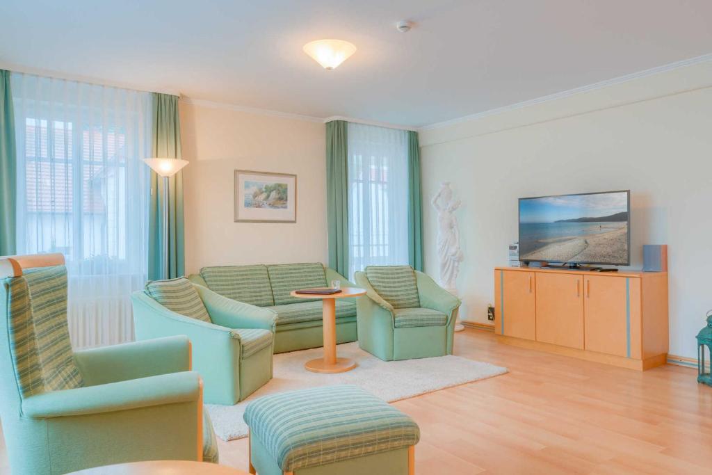 un salon avec un canapé, des chaises et une télévision dans l'établissement Villa Elfeld 2 Whg_ 718, à Binz