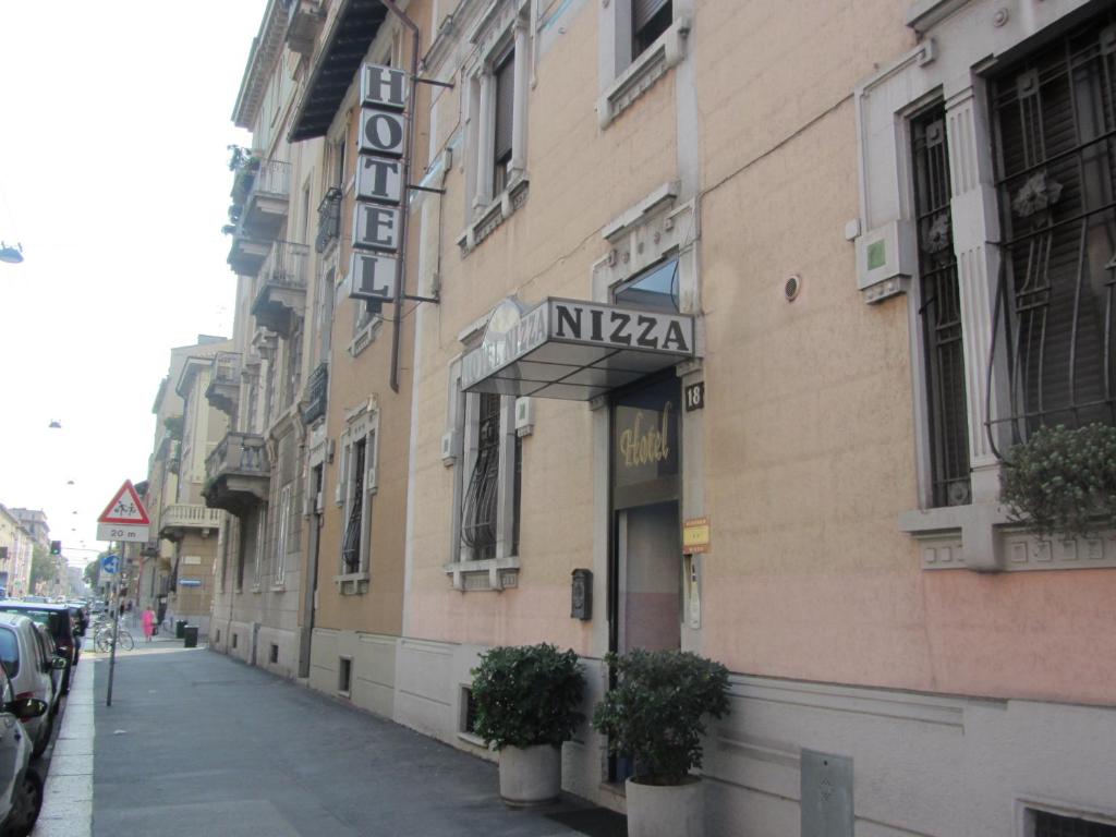 a building with a sign on the side of a street at Hotel Nizza in Milan