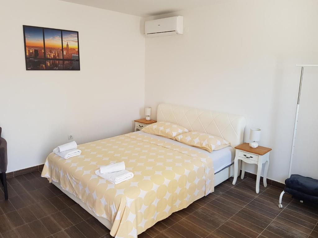 a small bedroom with a bed and a table at Apartments M&E in Mokošica