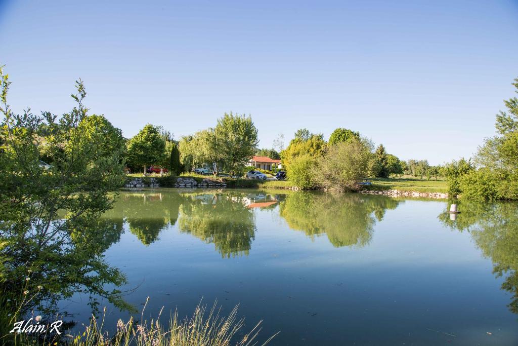 vistas a un lago con árboles y casas en PARADISE CHALLETS AND CAMPING, en Sarrecave