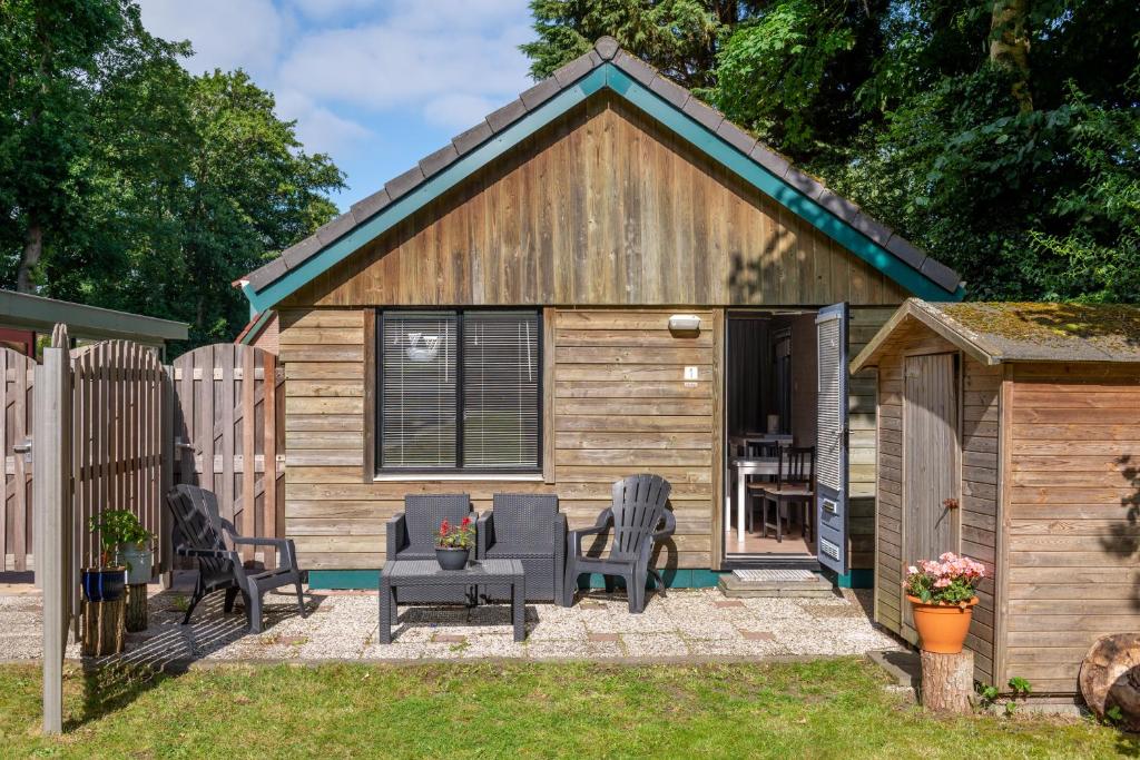 a tiny house with a patio and a fence at Vakantiehuis Duin Bos en Zee in Schoorl