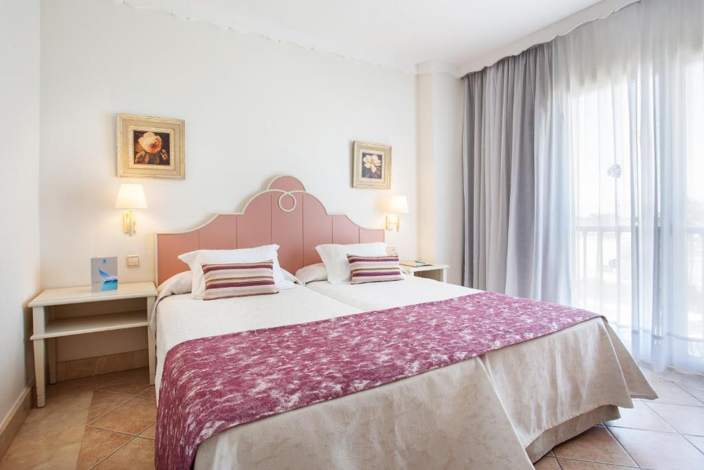 A bed or beds in a room at Grupotel Macarella Suites & Spa