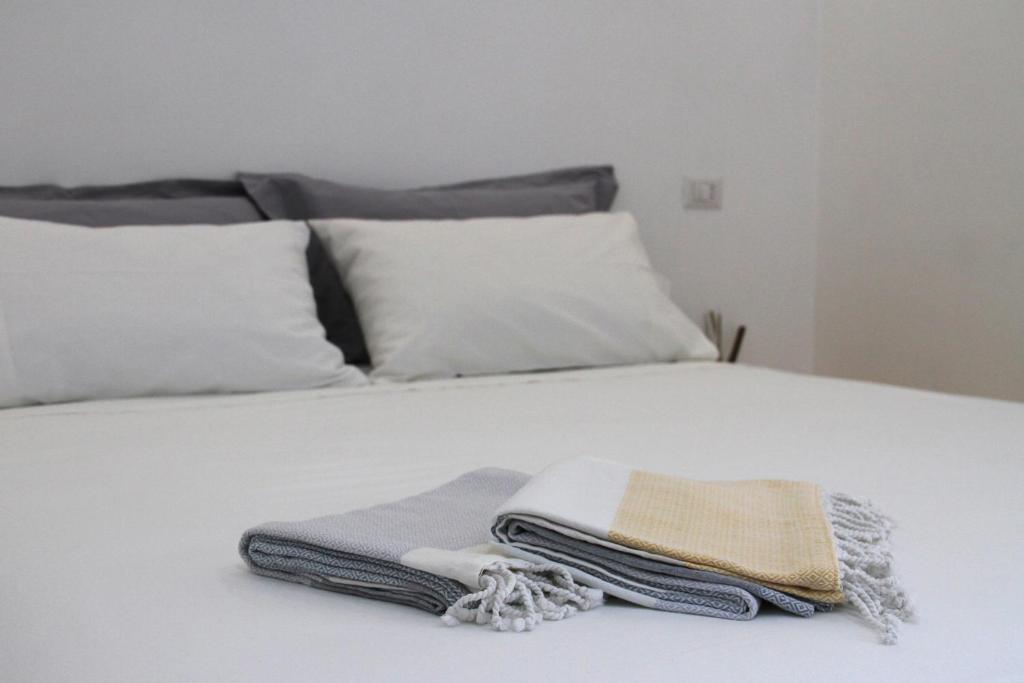 a white bed with two folded towels on it at LOFT 52 in Margherita di Savoia