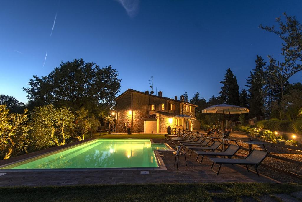 a swimming pool with chairs and a house at B&B Country House Poggio Del Drago in Ponticino