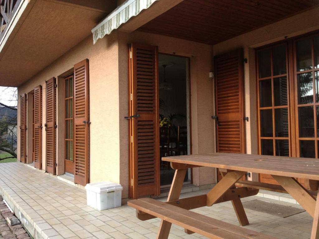 a wooden picnic table sitting outside of a house at location à la campagne aux portes de Mulhouse in Sausheim