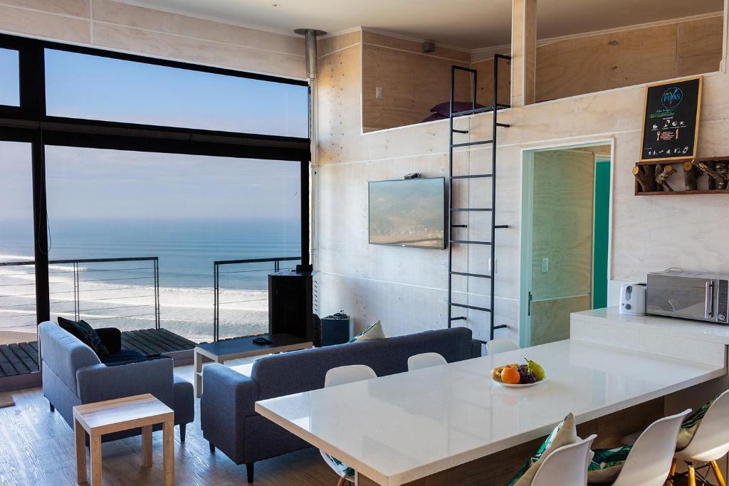 - un salon avec une table et des chaises donnant sur l'océan dans l'établissement Casa Las Puyas Top Hill Incredible View + Hot Tub, à Navidad