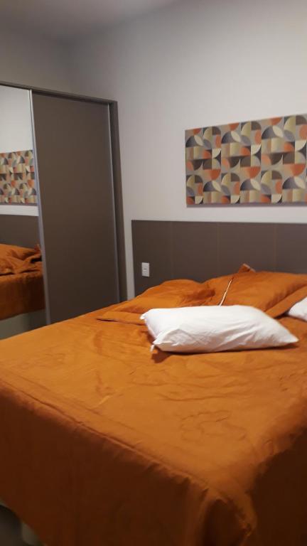 una cama con dos almohadas encima en Park Veredas Flat, en Rio Quente