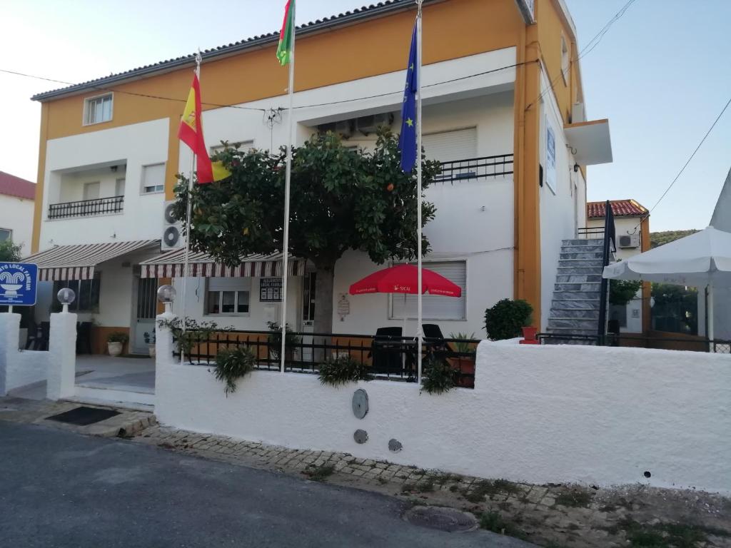 um edifício com bandeiras à sua frente em Alojamento Local Familiar em Monfortinho