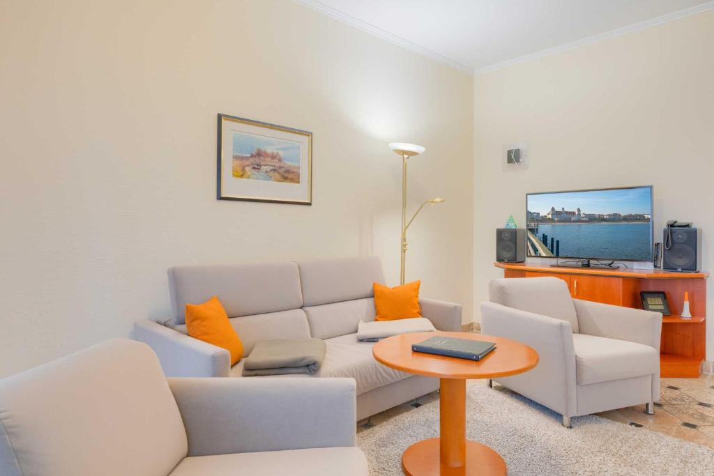 ein Wohnzimmer mit einer Couch und zwei Stühlen und einem Tisch in der Unterkunft Villa Seestern Whg. 760 in Binz