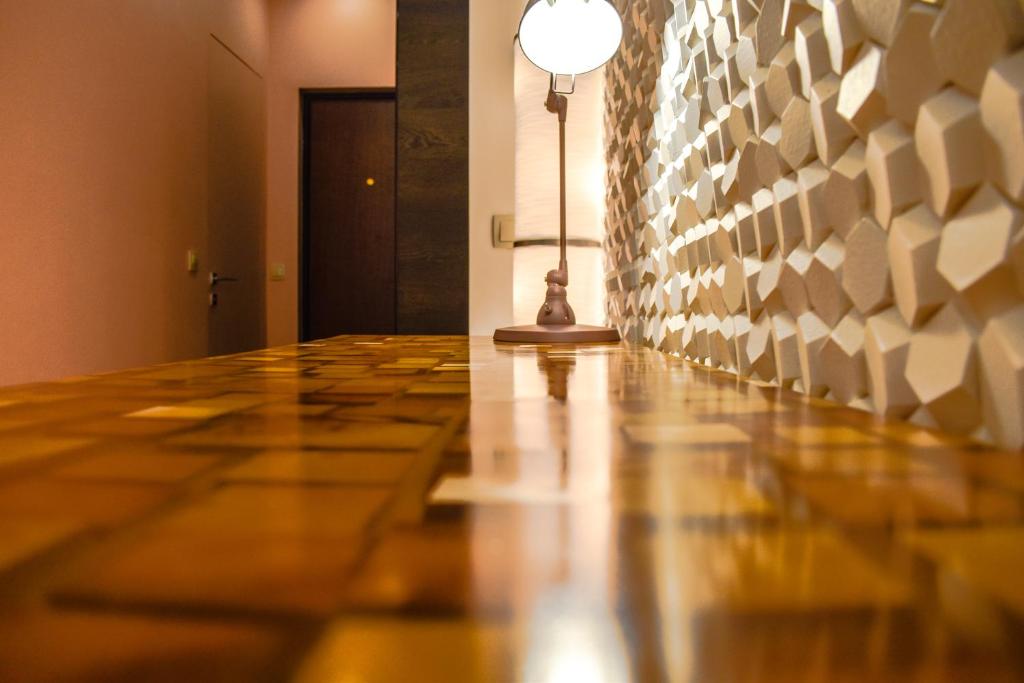 korytarzem z drewnianą podłogą i jasnym słupem w obiekcie АРТ-Отель w mieście Czerepowiec