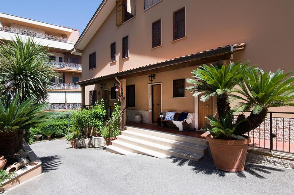 una casa con palmeras delante en Olympic Suite Roma en Roma