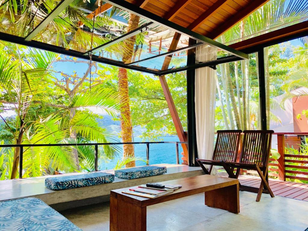 a living room with a couch and a table and a window at Casas Do Mar in Ilhabela