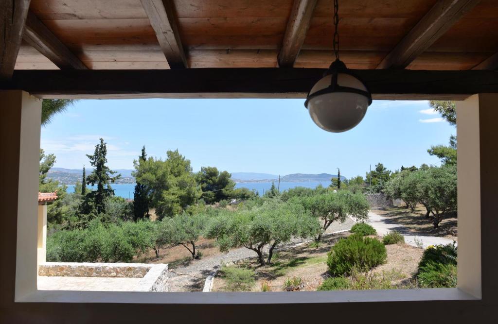 una finestra con vista su un campo di ulivi di Filoxenos Estia-Houses a Porto Heli