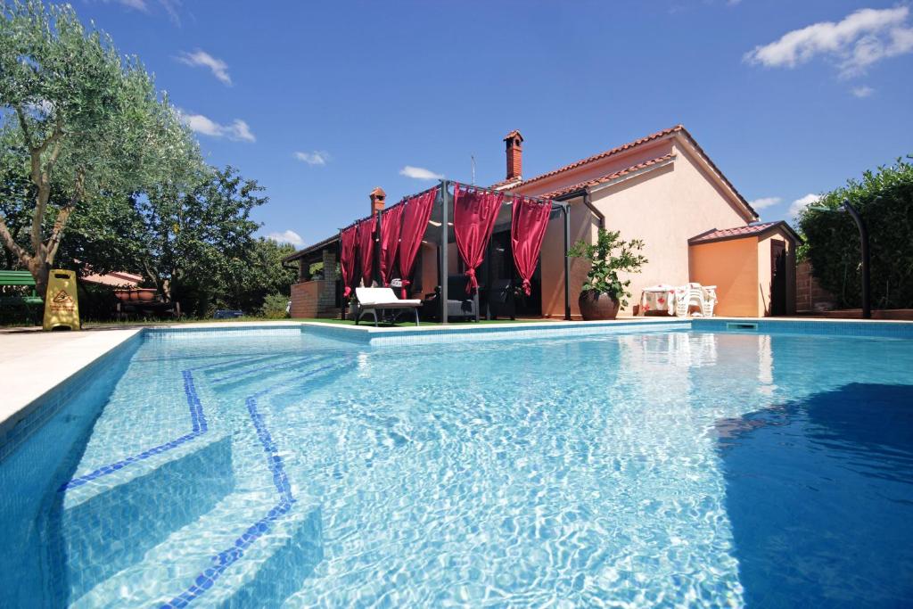 a swimming pool in front of a house at Apartments Mirna in Pula