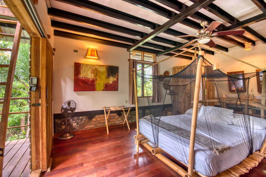 a bedroom with a canopy bed with a ceiling fan at Selvista Guesthouses in Balgue