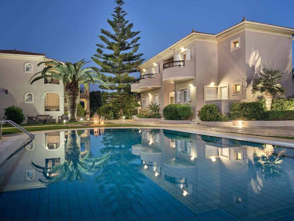 une grande maison avec une piscine en face de celle-ci dans l'établissement San Giorgios Maisonettes, à Laganas