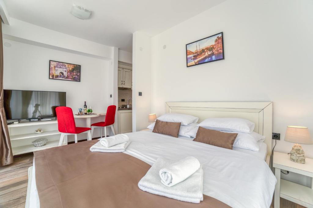 a bedroom with a large white bed and red chairs at Casa Nuova in Kotor