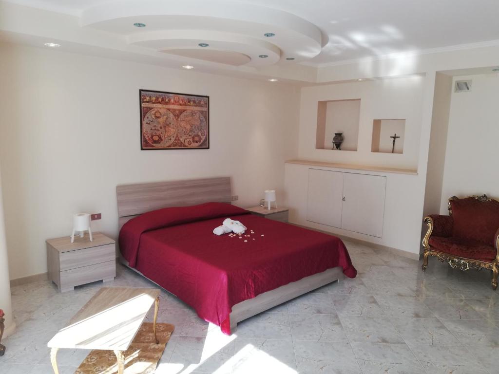 1 dormitorio con 1 cama roja y 1 silla en A Casa di Carla e Lucia, en Massafra