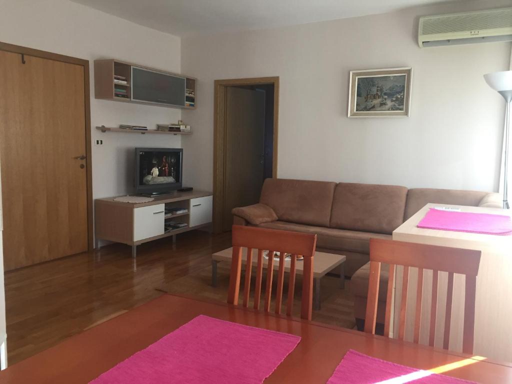 ein Wohnzimmer mit einem Sofa und einem Tisch in der Unterkunft Apartment Pavešić 1 in Mali Lošinj