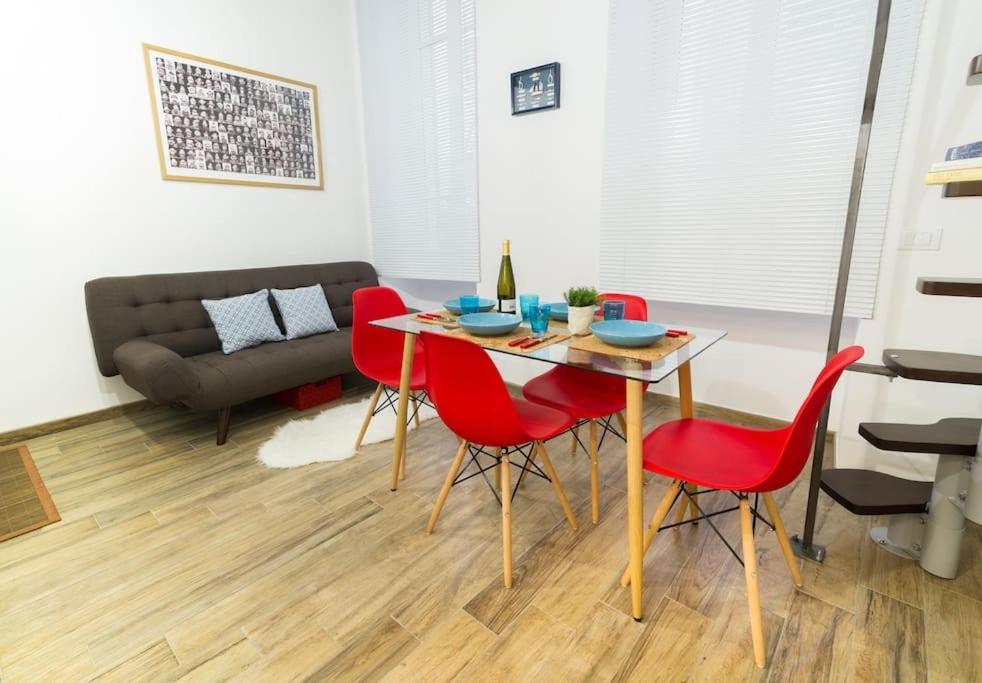 salon ze stołem i czerwonymi krzesłami w obiekcie Due MiniLoft, Sanremo Centro, AriaCondizionata, WiFi w San Remo