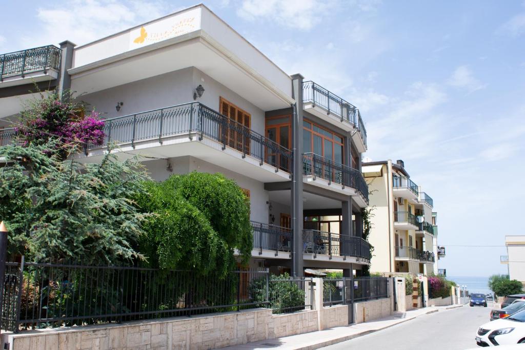 un edificio blanco con balcones en una calle en Villa Franca Mini Appartamenti, en Bisceglie