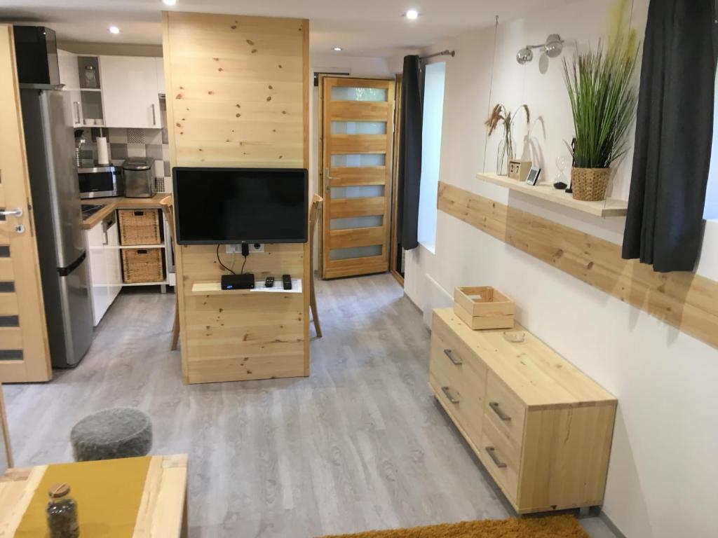 uma cozinha com armários de madeira e uma televisão de ecrã plano em Modern Apartman Deluxe em Alsóörs