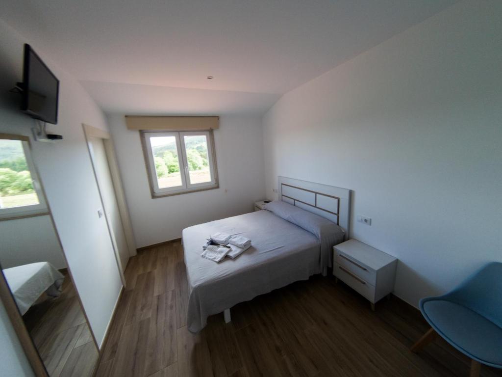 een kleine slaapkamer met een bed en een raam bij Albergue Casa Manola in Abeleiras