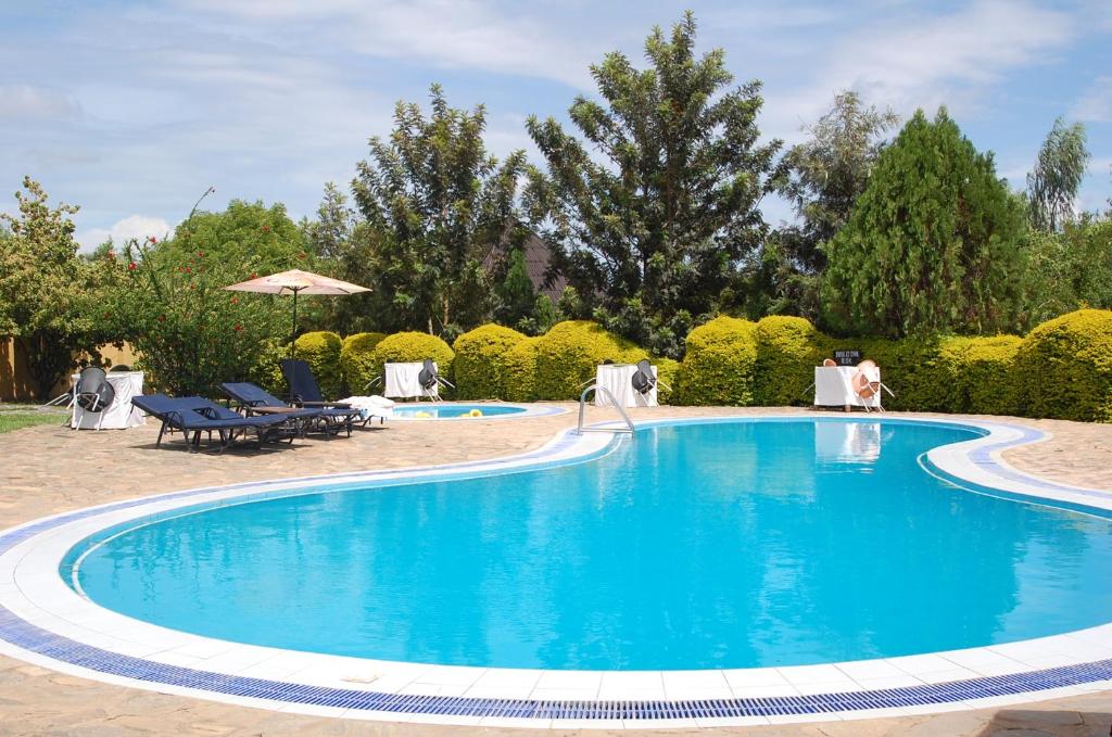 une grande piscine bleue dans une cour dans l'établissement White Castle Hotel Arua, à Gulu