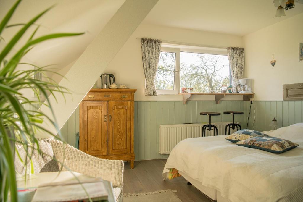 Schlafzimmer mit einem Bett und einem Fenster in der Unterkunft boerderijkamer Korenbloem in Onstwedde