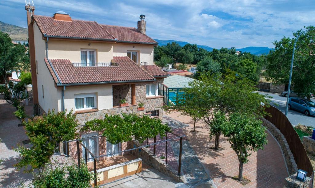 una casa con una valla y árboles delante de ella en El Mirador de la Atalaya en Trescasas