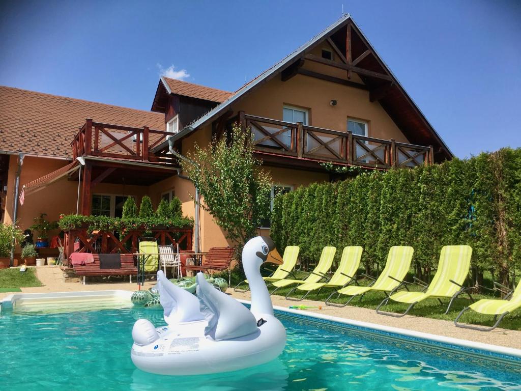 Dois cisnes estão a andar numa jangada numa piscina. em Apartments Lipno Serafin em Lipno nad Vltavou