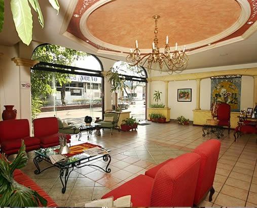 a large living room with red furniture and a chandelier at Hotel Calenda in Oaxaca City