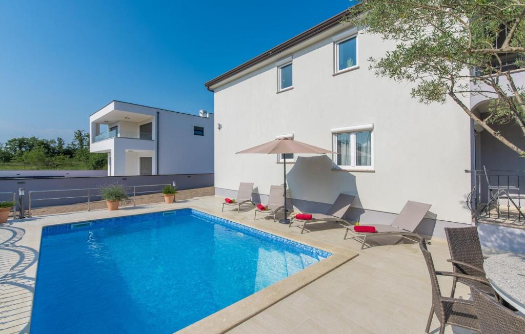 uma piscina com cadeiras e uma casa em Silver Holiday House em Poreč