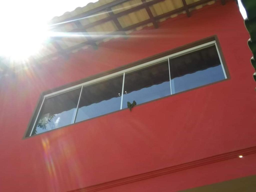 un edificio rojo con una fila de ventanas. en Chalé da Katia, en Ilhabela